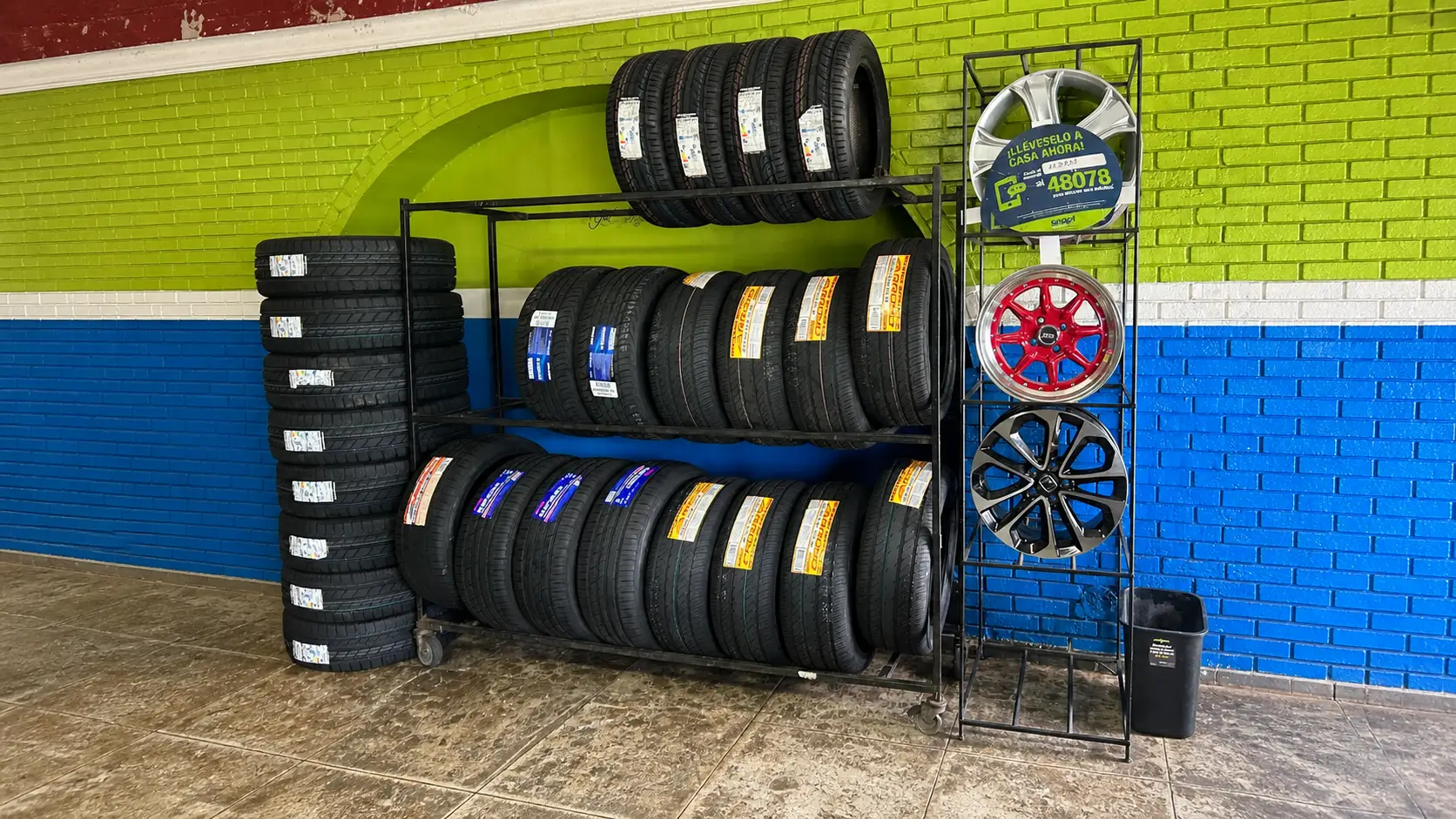 Tire racks against the lime and blue wall at Auto Tire Rivera